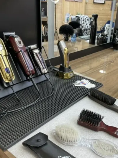 Gold clippers, brushes and strop on the counter at Mercia Barbers